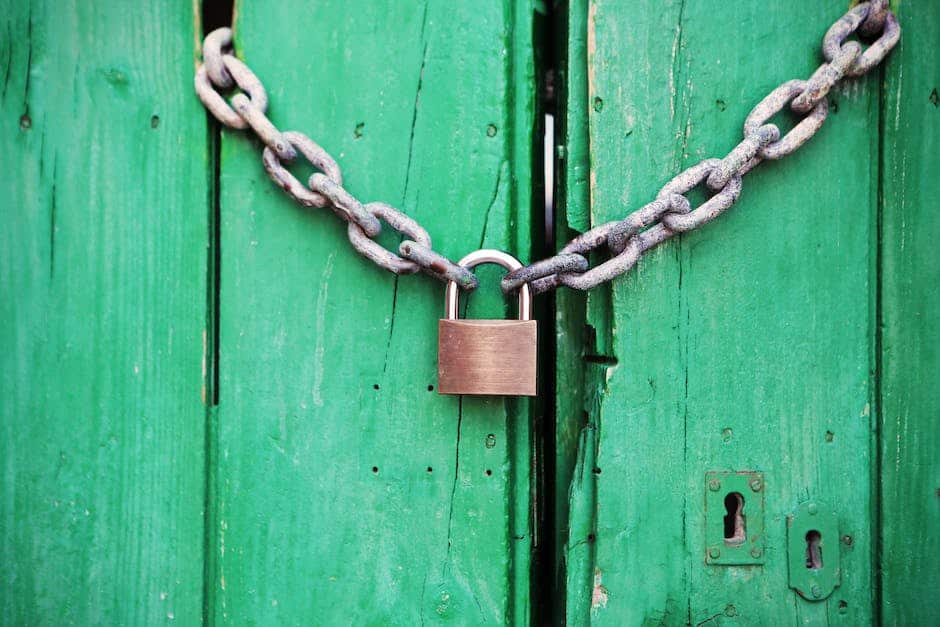 A padlock is attached to a green wooden door.