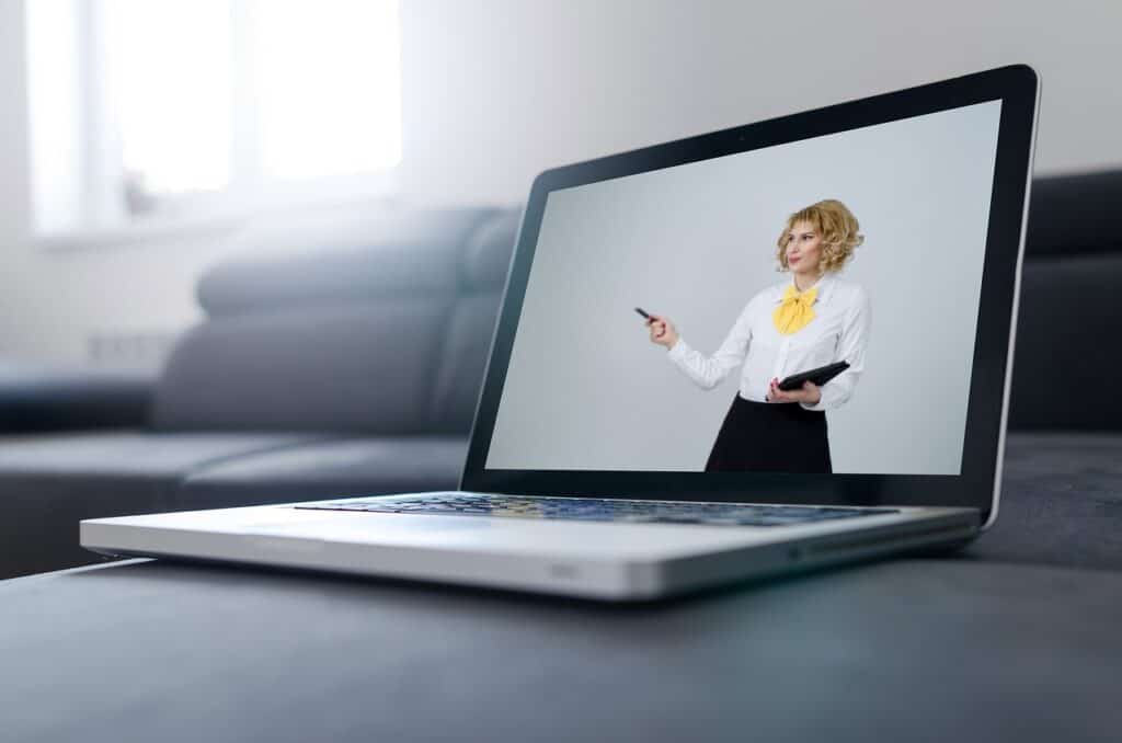 A woman in a business suit is on a laptop screen.