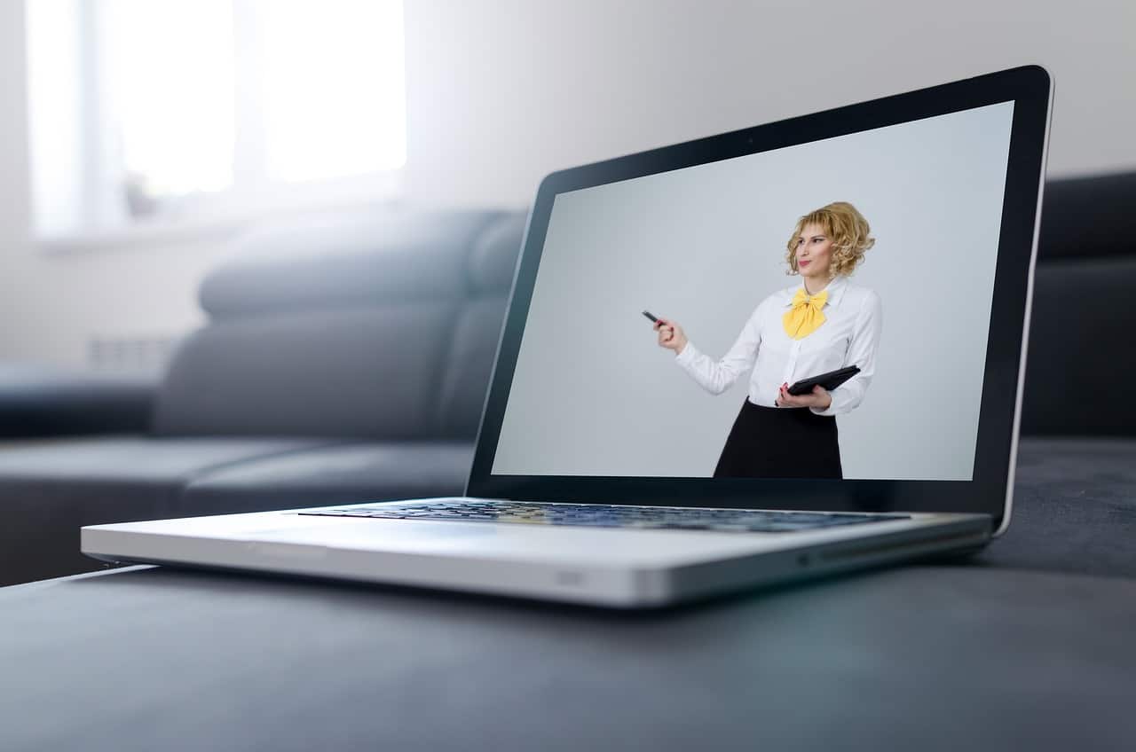 A woman in a business suit is on a laptop screen.