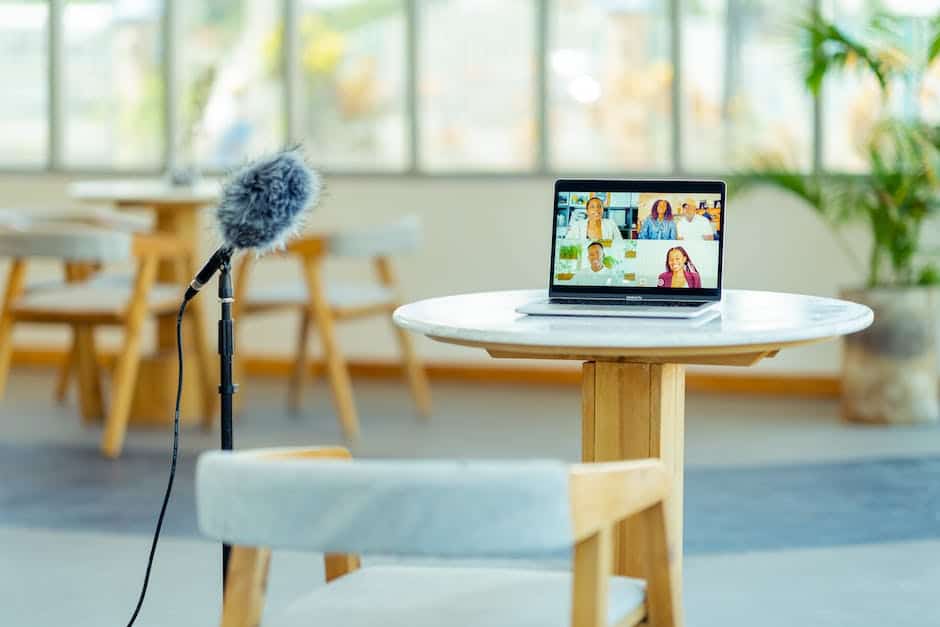 A microphone on a table with a laptop on it.