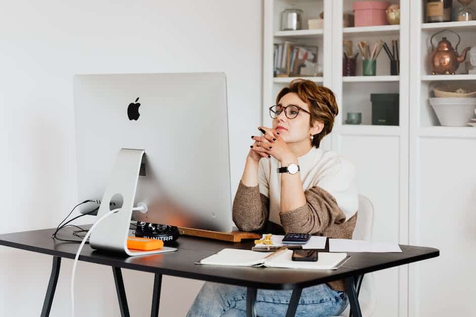 A woman sitting at a desk looking at her computer.