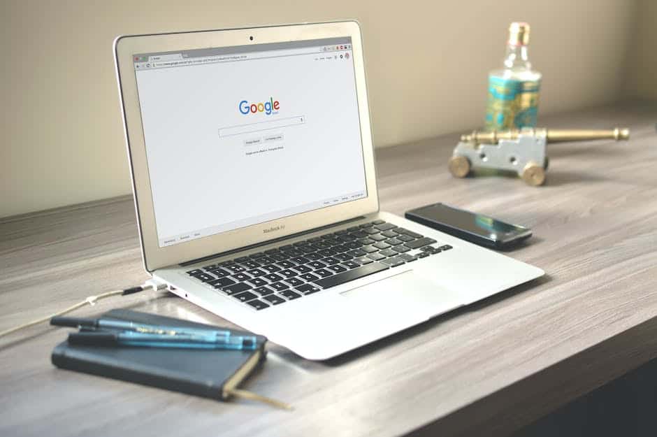 A laptop is sitting on a desk with google on it.