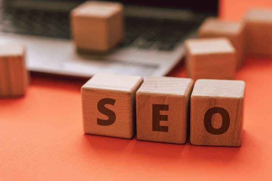 The word seo is spelled out on wooden blocks next to a laptop.