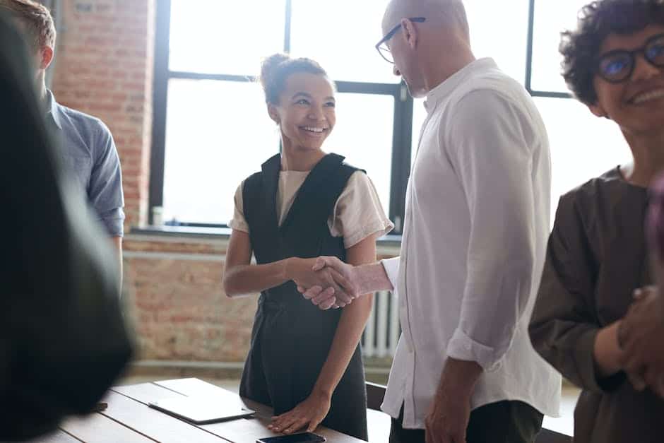 A group of business people shaking hands at a table.