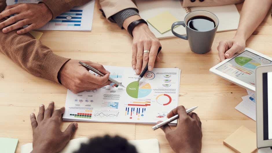 A group of people sitting around a table looking at graphs.
