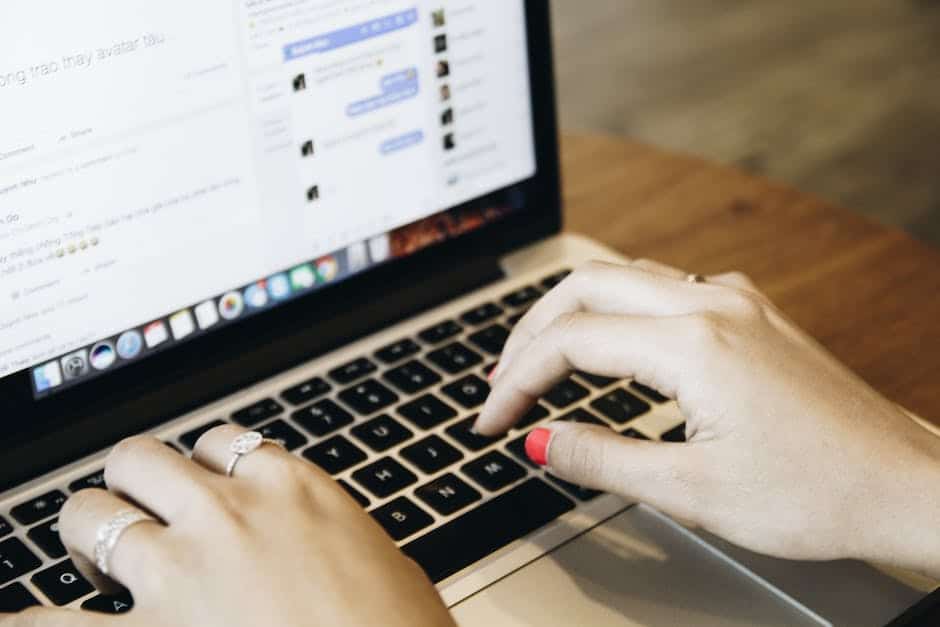 A woman typing on a laptop computer.