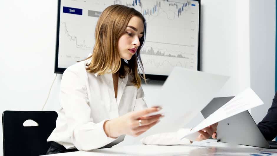 A man and woman sitting at a desk looking at papers.