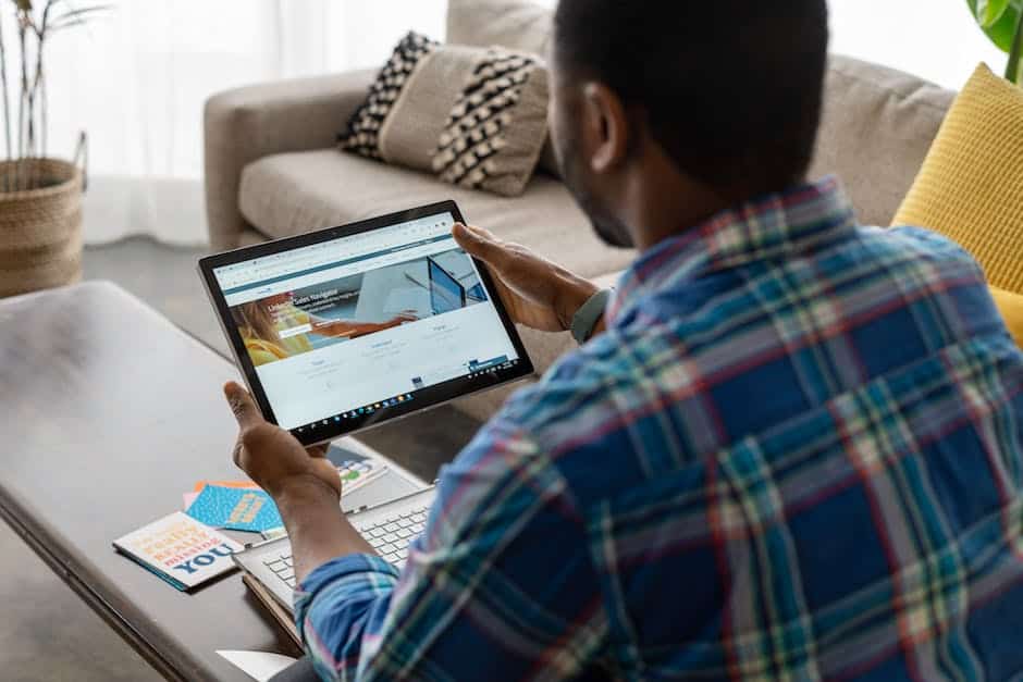 A man using a tablet computer in his living room.