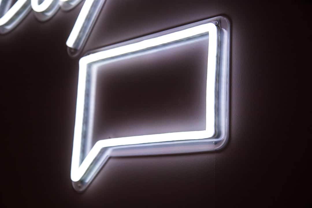 A neon sign with a speech bubble on it.