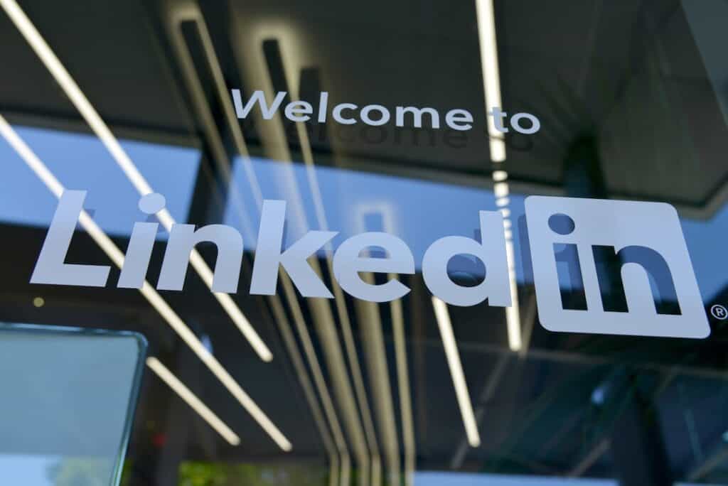 The linkedin logo is seen on a glass door.