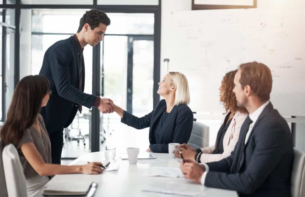 A group of business people shaking hands at a meeting.